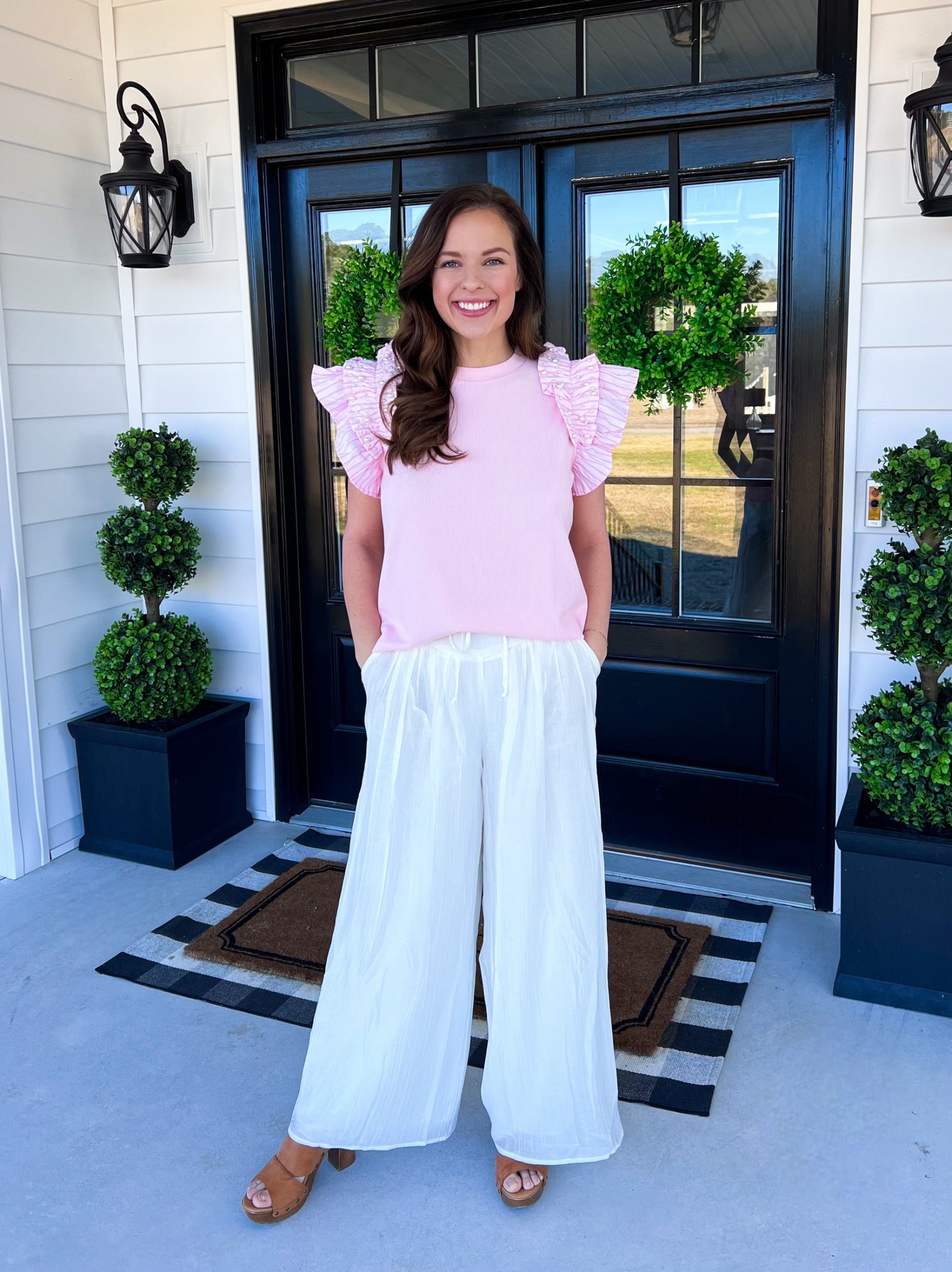 Elegant white wide-leg pants with a flowy, lightweight design, perfect for warm-weather styling. Features a relaxed fit, subtle texture, and a comfortable elastic waistband. Styled here with a pink ruffle-sleeve top and wooden platform sandals for a chic, effortless look. Ideal for brunch, beach vacations, or casual days out. ☀️✨