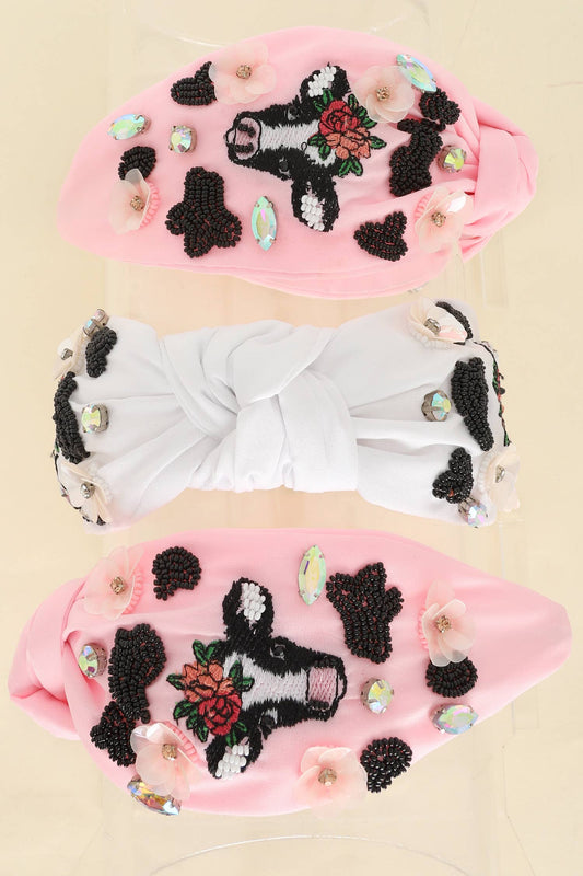  A set of three knotted headbands in pink and white, featuring intricate beaded cow and floral designs with rhinestone embellishments.