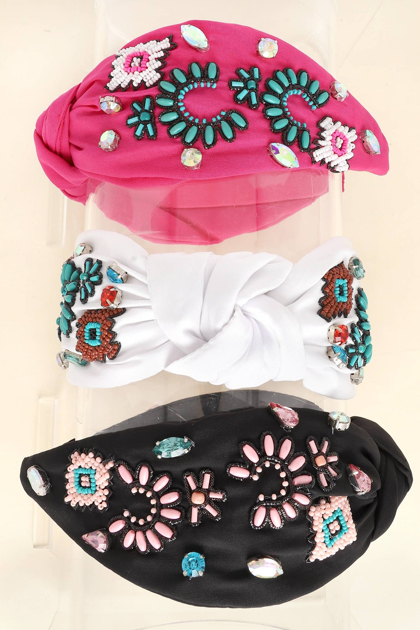 A set of three knotted headbands in pink, black, and white, featuring intricate beaded floral and geometric designs with turquoise accents and rhinestones.